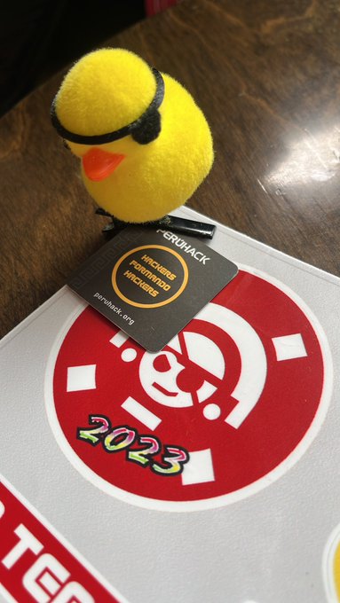 Patito amarillo con parche de PERÚHACK sobre un sticker del Tumi Hack 2023
