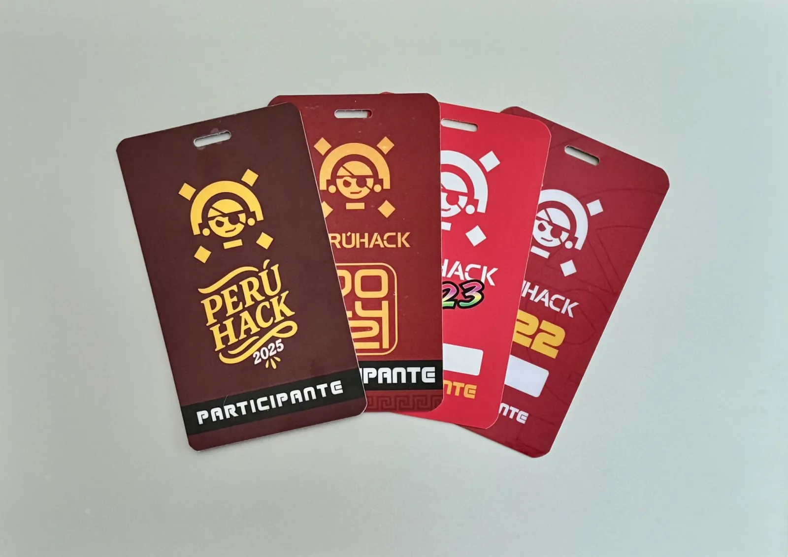 Colección de badges de participante de PERÚHACK 2022, 2023, 2024 y 2025 en abanico