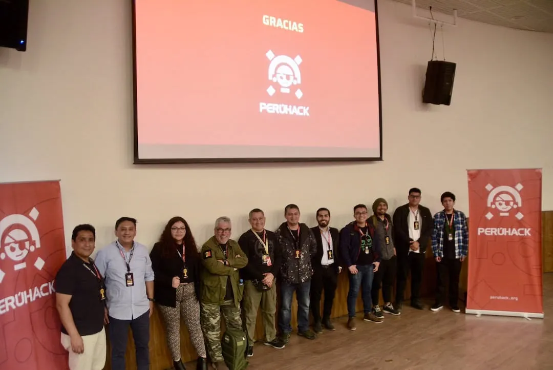 Foto grupal de speakers y organización de PERÚHACK 2022 frente a la pantalla de cierre