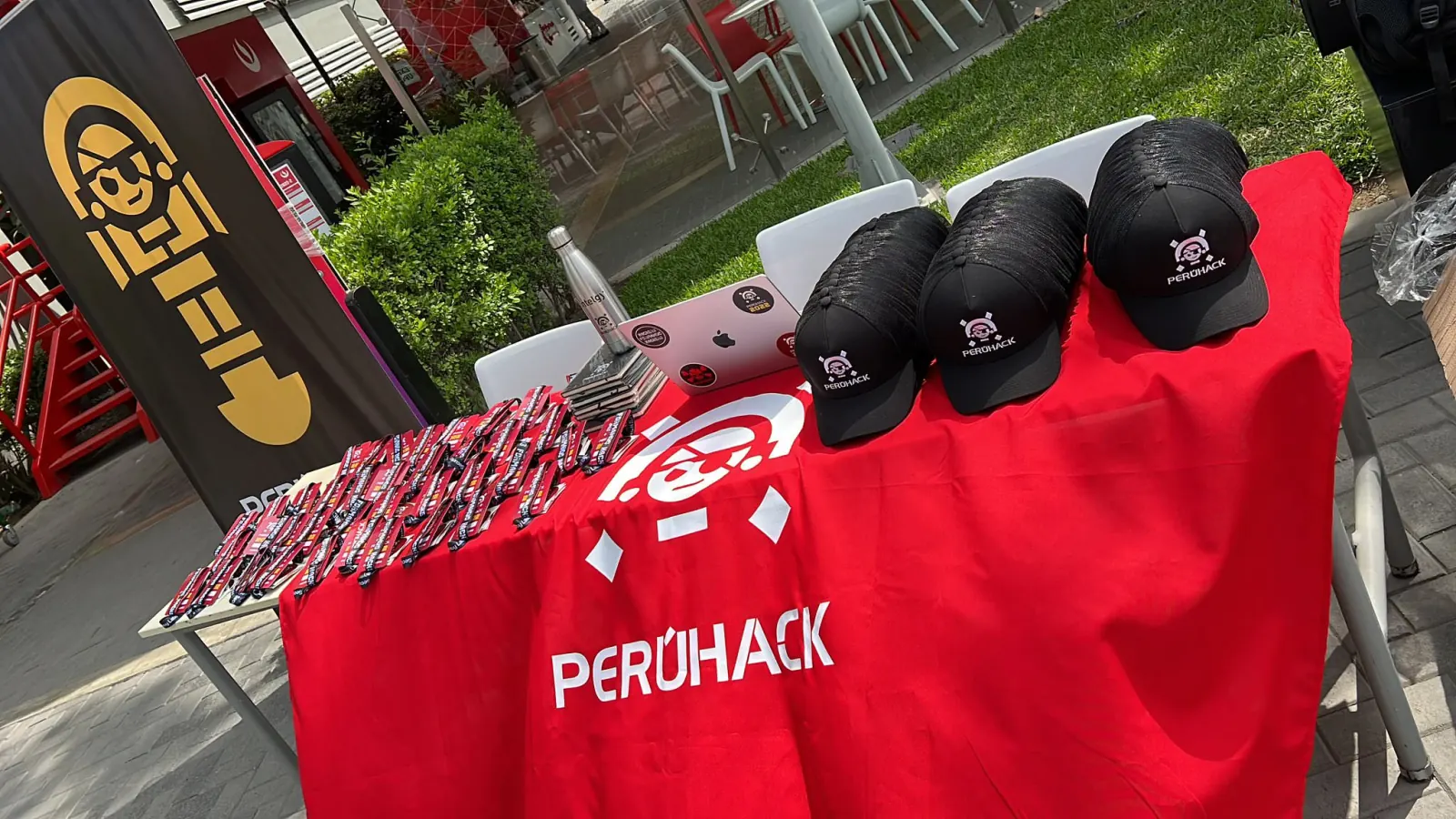 Mesa de bienvenida con gorras y merchandising de PERÚHACK 2022