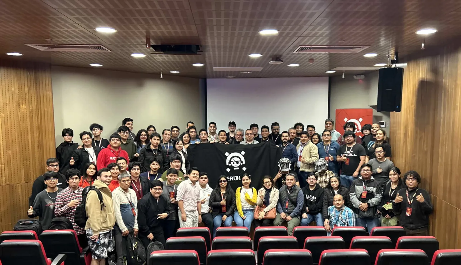 Foto grupal de la comunidad PERÚHACK 2024 en el auditorio de la UPC