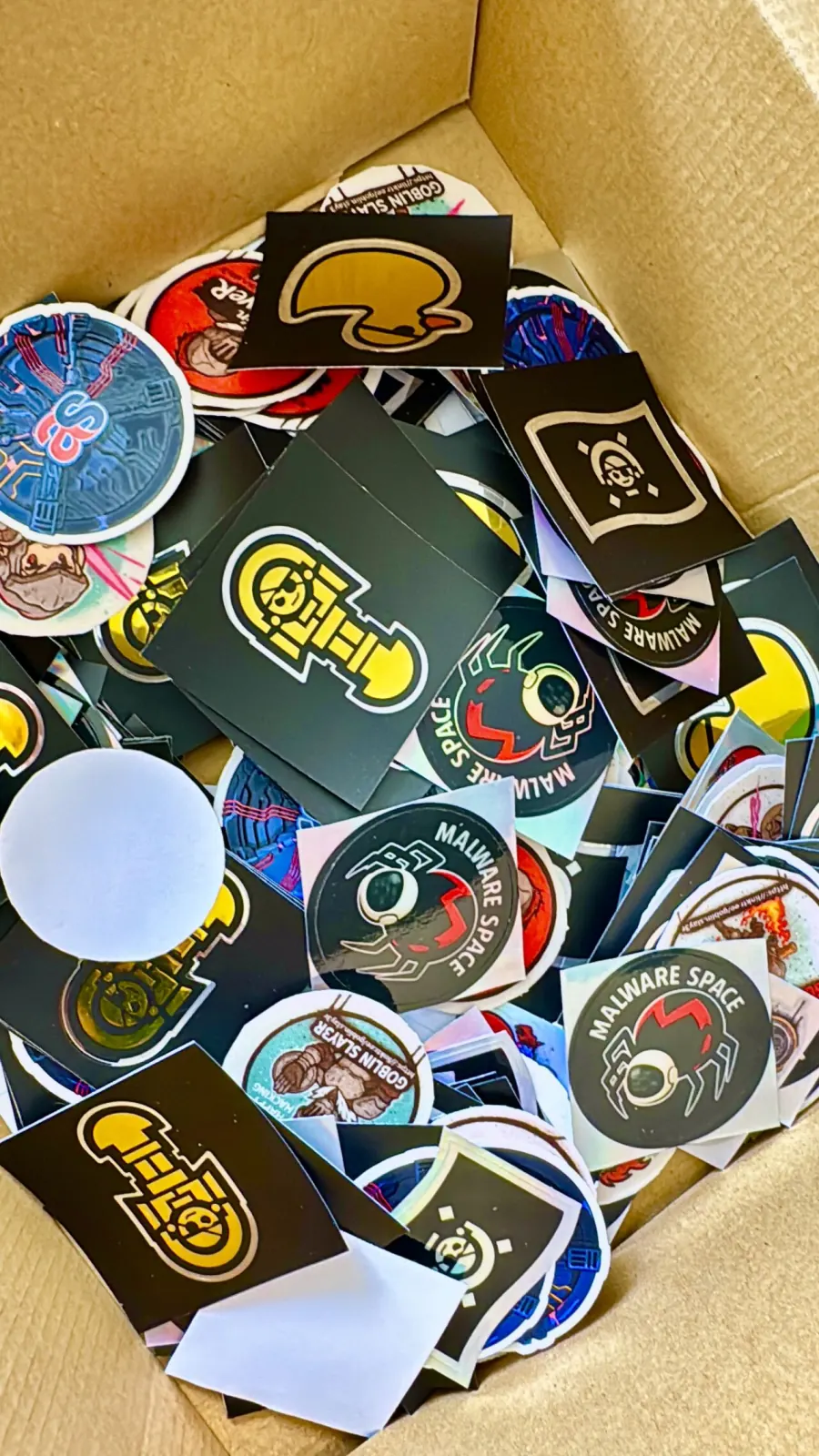 Caja llena de stickers de PERÚHACK y comunidades