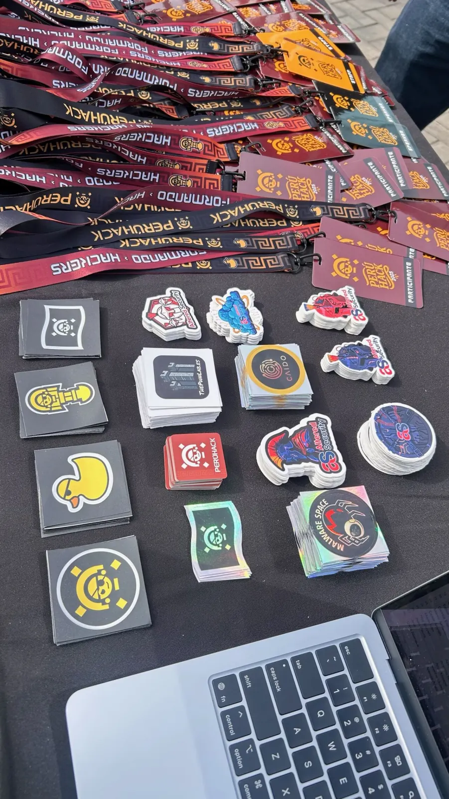 Stickers de PERÚHACK 2025 junto a una laptop