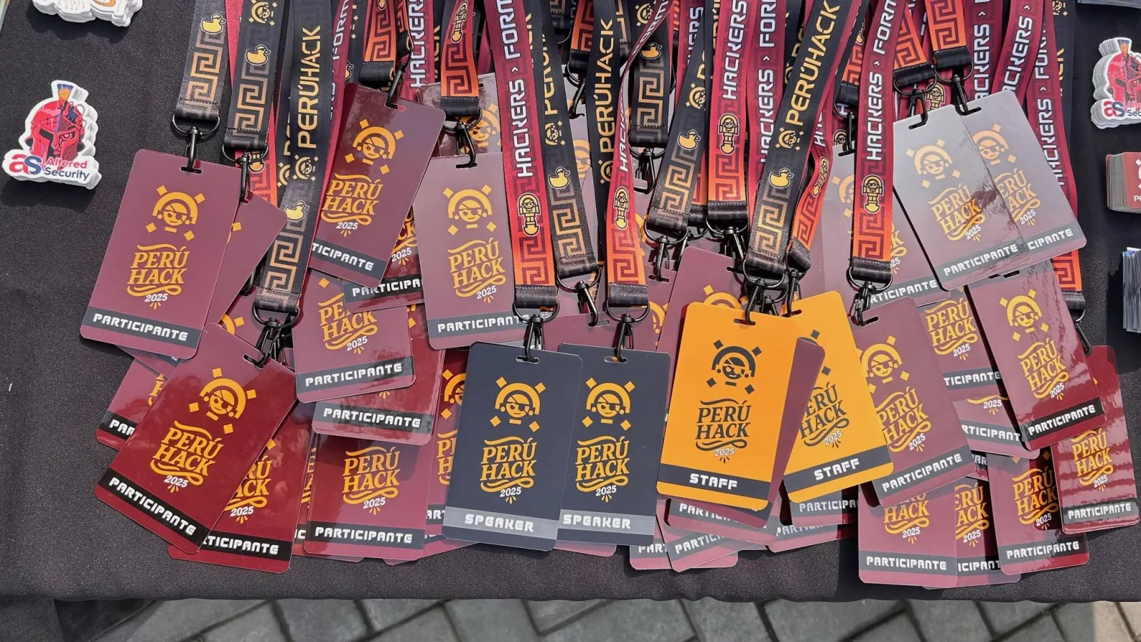 Mesa de acreditación de PERÚHACK 2025 con badges y lanyards